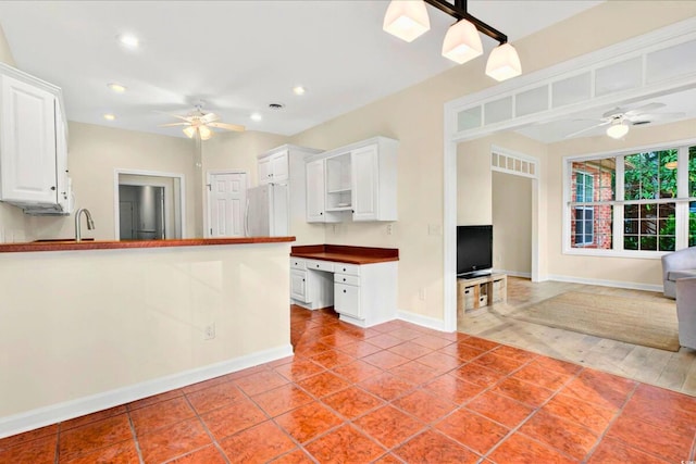 154 Windsor Cir SW, Ocean Isle Beach, NC 28469 - kitchen featuring a ceiling fan, freestanding refrigerator, white cabinetry, baseboards, and dark countertops