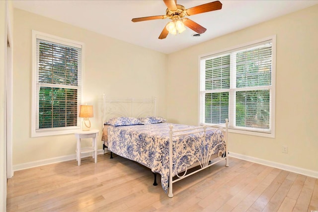 154 Windsor Cir SW, Ocean Isle Beach, NC 28469 - bedroom with wood finished floors, multiple windows, and baseboards