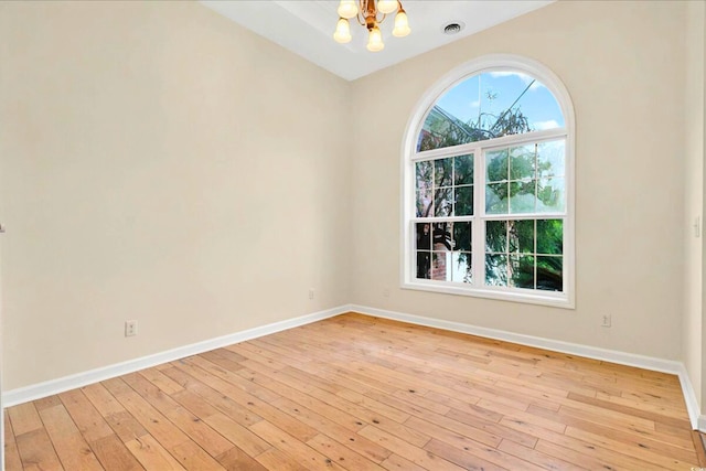 154 Windsor Cir SW, Ocean Isle Beach, NC 28469 - unfurnished room with a chandelier, baseboards, and light wood-style flooring