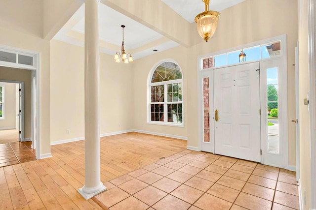 154 Windsor Cir SW, Ocean Isle Beach, NC 28469 - foyer entrance featuring light wood-style floors, a chandelier, a raised ceiling, and baseboards