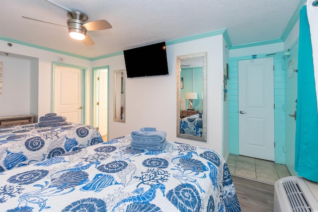 bedroom featuring a textured ceiling, ceiling fan, crown molding, and wood finished floors