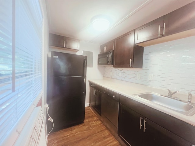 401 Alder St, Myrtle Beach, SC 29577 - kitchen with black appliances, a sink, light wood-style floors, decorative backsplash, and light countertops