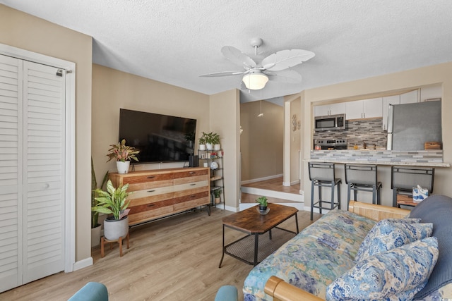 625 N Waccamaw Dr Unit 107, Murrells Inlet, SC 29576 - living area featuring baseboards, ceiling fan, light wood-type flooring, and a textured ceiling