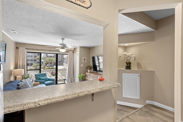 625 N Waccamaw Dr Unit 107, Murrells Inlet, SC 29576 - kitchen with light wood-style floors, a ceiling fan, open floor plan, baseboards, and a textured ceiling