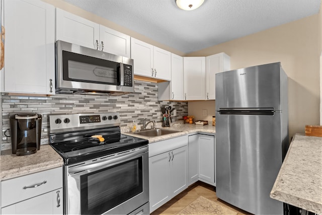 625 N Waccamaw Dr Unit 107, Murrells Inlet, SC 29576 - kitchen featuring appliances with stainless steel finishes, a sink, light countertops, white cabinets, and decorative backsplash