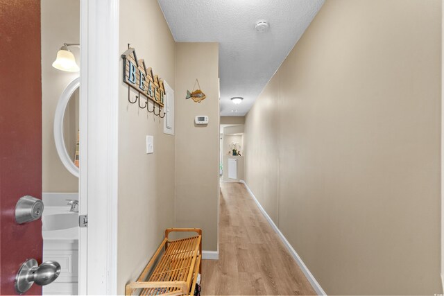 625 N Waccamaw Dr Unit 107, Murrells Inlet, SC 29576 - corridor with light wood-style floors, baseboards, and a textured ceiling