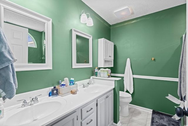 full bathroom with double vanity, toilet, marble look tiles, and a textured ceiling