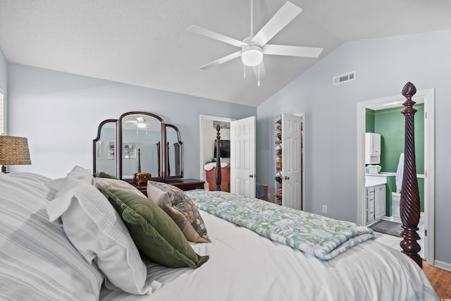bedroom with lofted ceiling, wood finished floors, ceiling fan, and ensuite bath