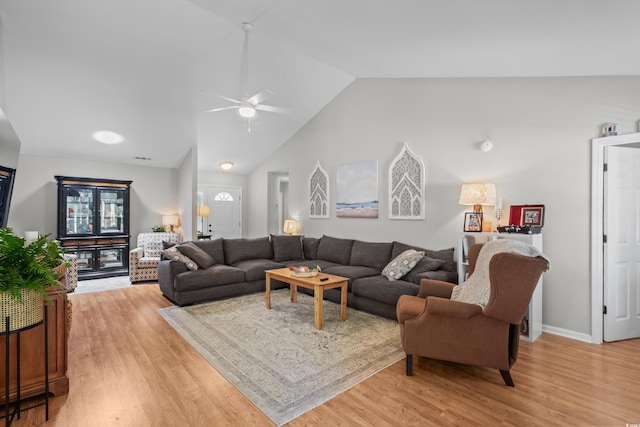 living area with lofted ceiling, light wood-type flooring, and ceiling fan