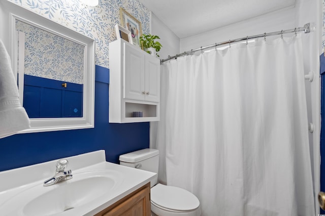 full bath featuring toilet, wallpapered walls, vanity, and curtained shower