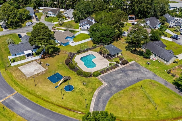 aerial view of property and surrounding area featuring a pool and nearby suburban area