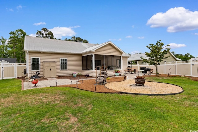back of house featuring an outdoor fire pit, a patio area, a sunroom, and metal roof