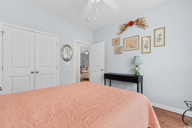 bedroom with wood finished floors, a closet, baseboards, and a ceiling fan