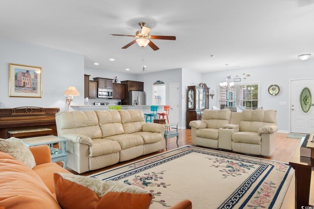 living room featuring a ceiling fan, a chandelier, wood finished floors, recessed lighting, and baseboards