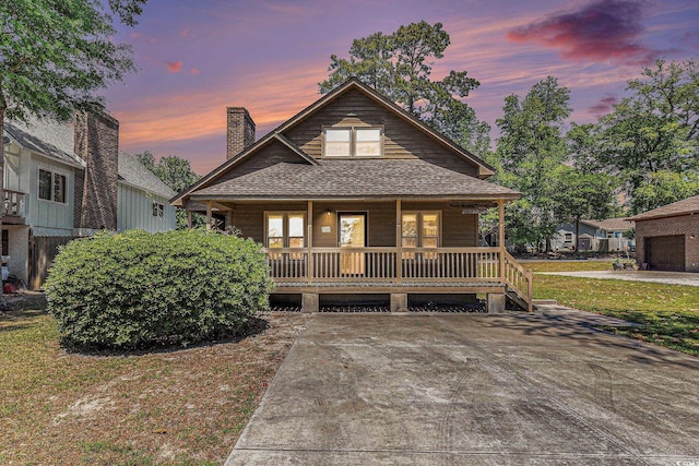 2191 Liberty Cir, Little River, SC 29566 - view of front facade featuring covered porch, a chimney, and a shingled roof