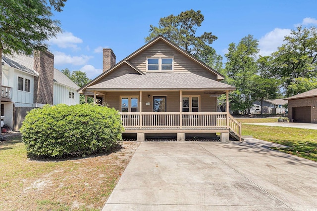 2191 Liberty Cir, Little River, SC 29566 - view of front of property featuring covered porch, roof with shingles, and a chimney