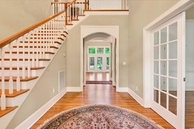 79 Windsor Cir SW, Ocean Isle Beach, NC 28469 - foyer entrance with wood finished floors, french doors, a high ceiling, arched walkways, and stairs