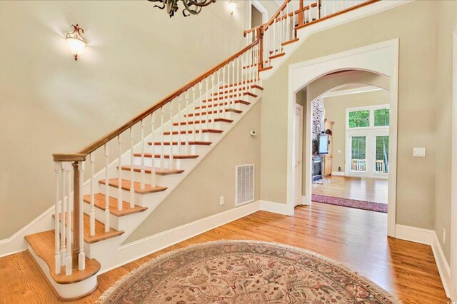 79 Windsor Cir SW, Ocean Isle Beach, NC 28469 - stairs featuring arched walkways, wood finished floors, a high ceiling, and baseboards