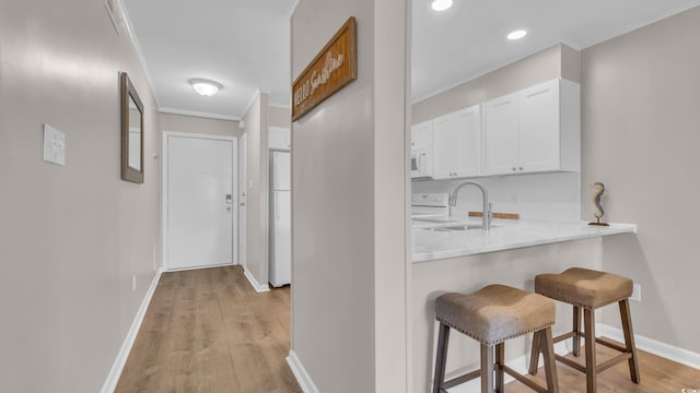 9501 Shore Dr Unit A-211, Myrtle Beach, SC 29572 - hallway with a sink, light wood-style floors, baseboards, crown molding, and recessed lighting