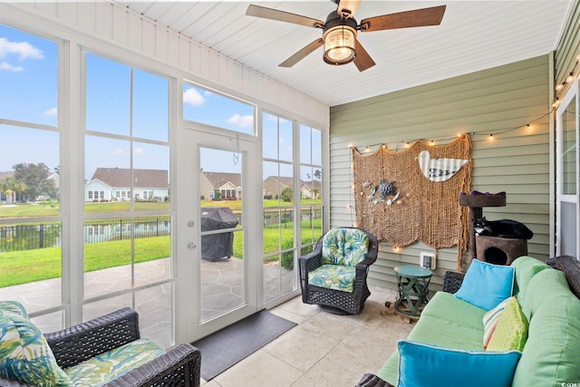 sunroom / solarium featuring ceiling fan, a water view, an outdoor hangout area, and a residential view