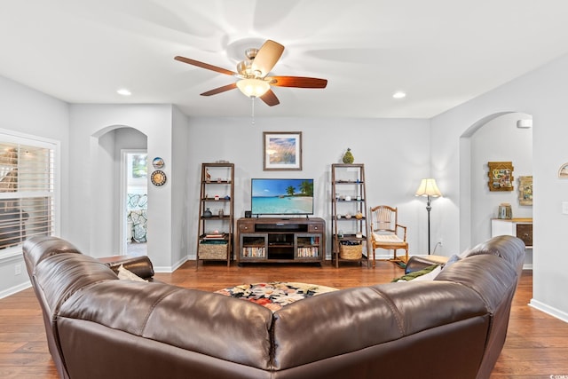 living room with arched walkways, ceiling fan, wood finished floors, recessed lighting, and baseboards