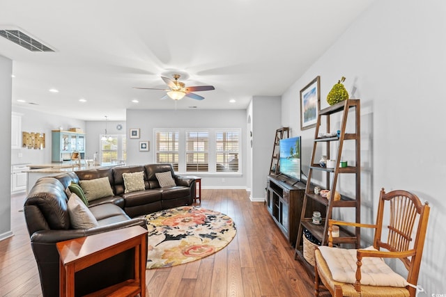 living area featuring ceiling fan, hardwood / wood-style floors, baseboards, and recessed lighting
