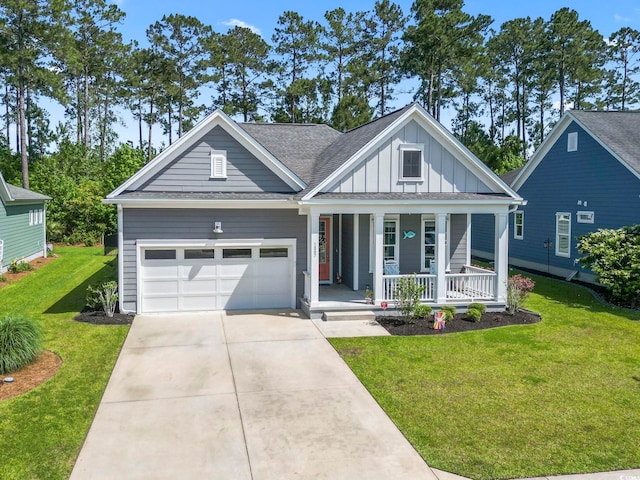 view of front of home with board and batten siding, covered porch, an attached garage, concrete driveway, and a front yard