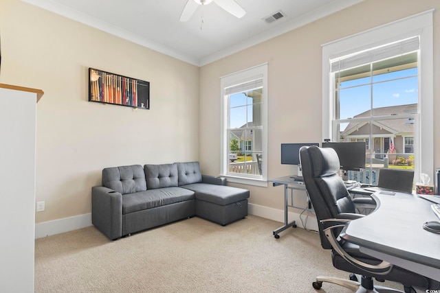carpeted home office featuring healthy amount of natural light, ceiling fan, baseboards, and ornamental molding