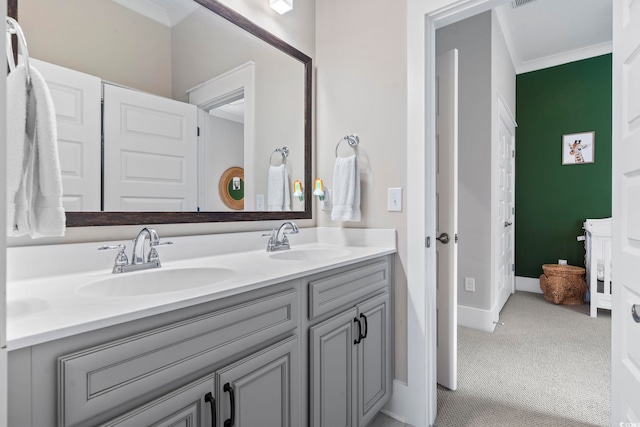 bathroom featuring double vanity, crown molding, and baseboards