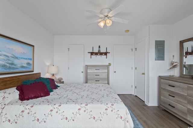 bedroom with electric panel, dark wood-style floors, a ceiling fan, and baseboards