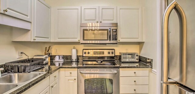 9780 Leyland Dr Unit 112, Myrtle Beach, SC 29572 - kitchen with stainless steel appliances, white cabinets, dark countertops, and a sink