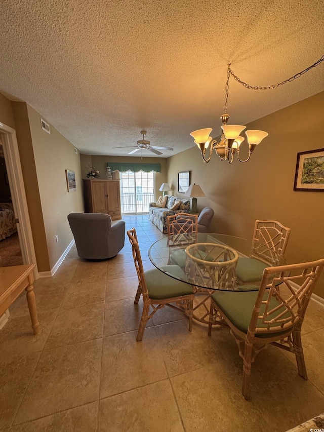 dining room featuring a textured ceiling, baseboards, light tile patterned floors, a ceiling fan, and a chandelier