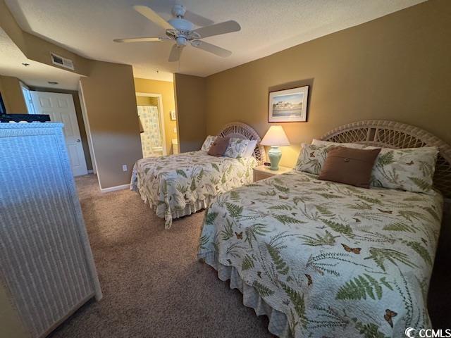 bedroom with carpet, a ceiling fan, ensuite bathroom, and baseboards