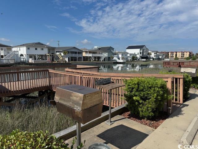 dock featuring a residential view and a deck with water view
