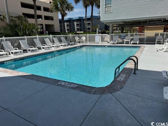 community pool with fence and a patio