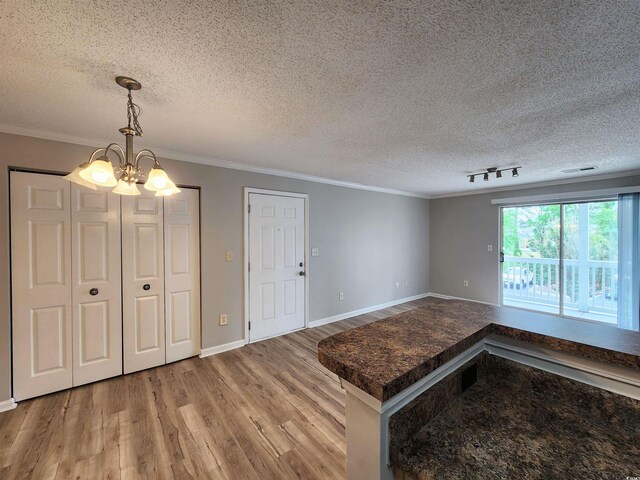 3786 Hitchcock Way Unit 321, Myrtle Beach, SC 29577 - unfurnished dining area featuring a chandelier, wood finished floors, a textured ceiling, ornamental molding, and baseboards
