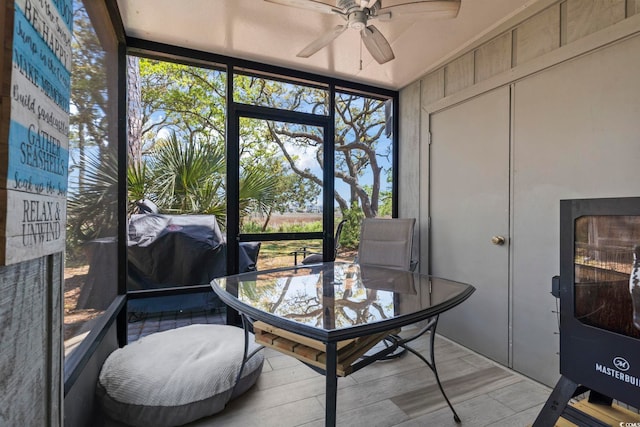 sunroom featuring a ceiling fan and outdoor dining area