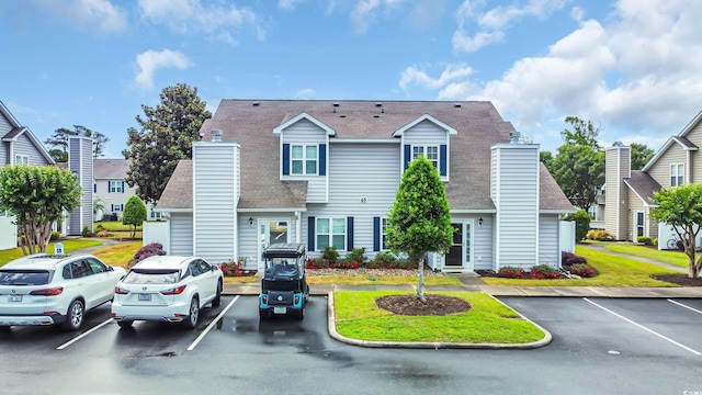 503 20th Ave N Unit 46B, North Myrtle Beach, SC 29582 - view of front facade featuring a chimney, uncovered parking, and a shingled roof