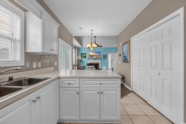 503 20th Ave N Unit 46B, North Myrtle Beach, SC 29582 - kitchen with a peninsula, white cabinetry, a chandelier, light countertops, and a sink