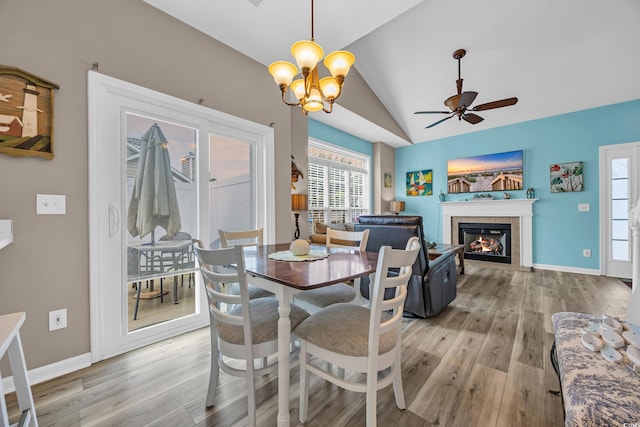 503 20th Ave N Unit 46B, North Myrtle Beach, SC 29582 - dining area featuring vaulted ceiling, light wood-style flooring, a fireplace, a ceiling fan, and a chandelier