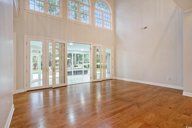 78 Oakmont Dr, Pawleys Island, SC 29585 - unfurnished living room with french doors, wood finished floors, a high ceiling, and baseboards