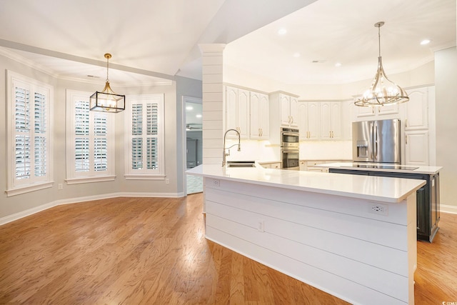 78 Oakmont Dr, Pawleys Island, SC 29585 - kitchen with appliances with stainless steel finishes, a chandelier, a sink, light wood-style flooring, and ornamental molding
