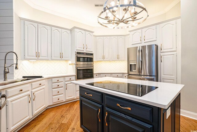 78 Oakmont Dr, Pawleys Island, SC 29585 - kitchen featuring appliances with stainless steel finishes, white cabinets, light countertops, ornamental molding, and decorative backsplash