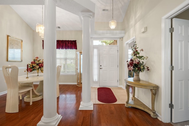 entryway featuring decorative columns, wood finished floors, a chandelier, and baseboards