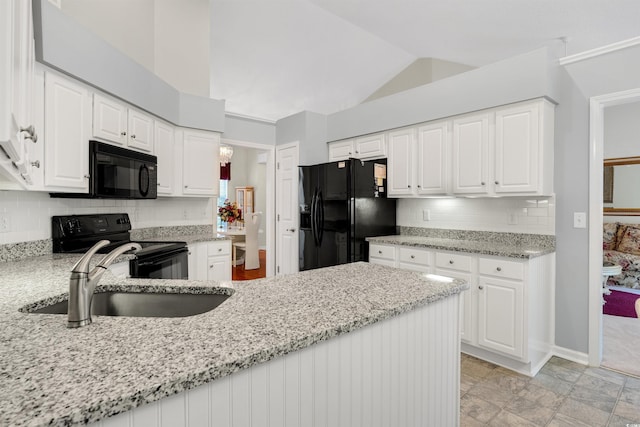 kitchen with black appliances, a sink, light stone counters, vaulted ceiling, and backsplash