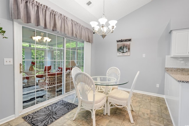 dining room featuring a chandelier, lofted ceiling, baseboards, and light stone finish floors