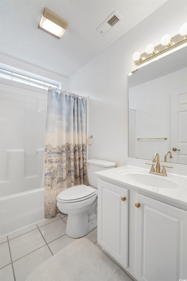 bathroom featuring toilet, tile patterned floors, vanity, shower / bathtub combination with curtain, and a textured ceiling