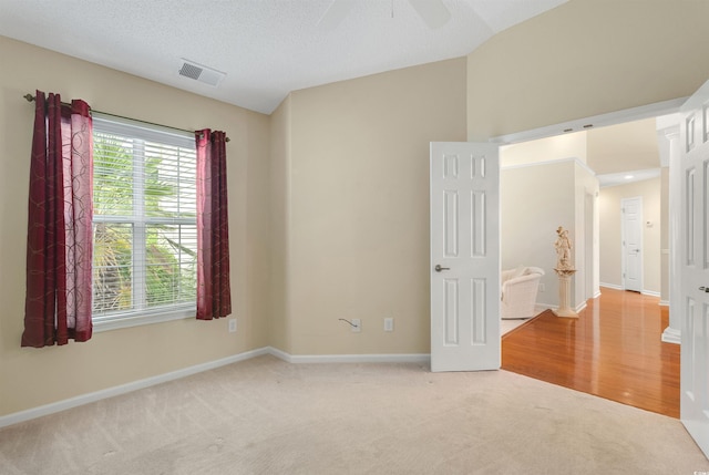 unfurnished room featuring light carpet, baseboards, and ceiling fan
