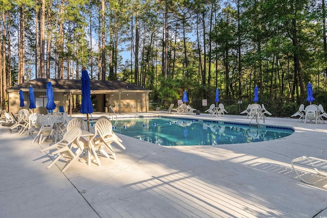 community pool with fence and a patio