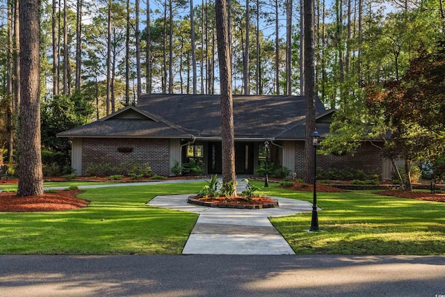 view of front of home with brick siding and a front lawn